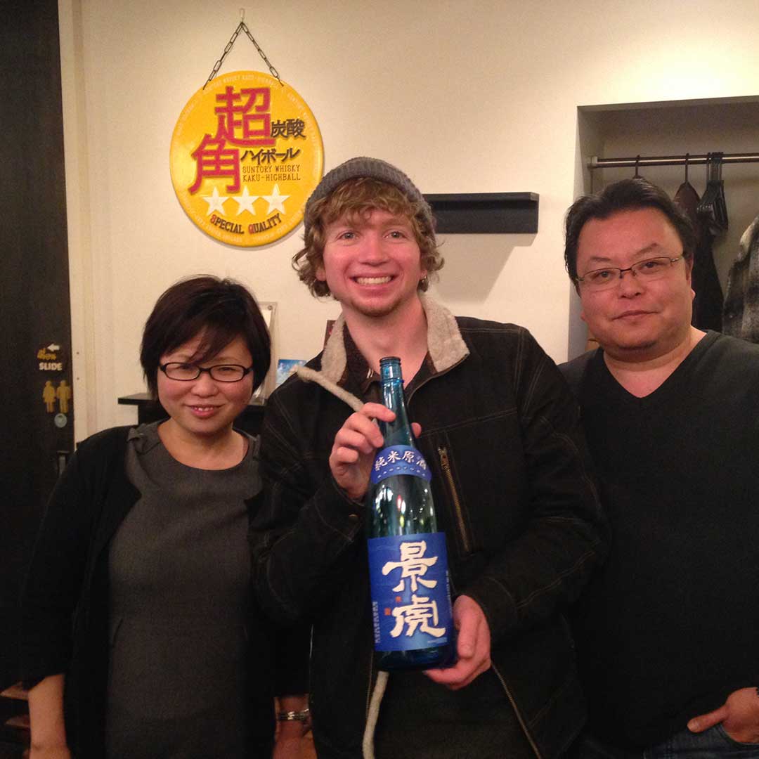 Tom holding a bottle of Sake